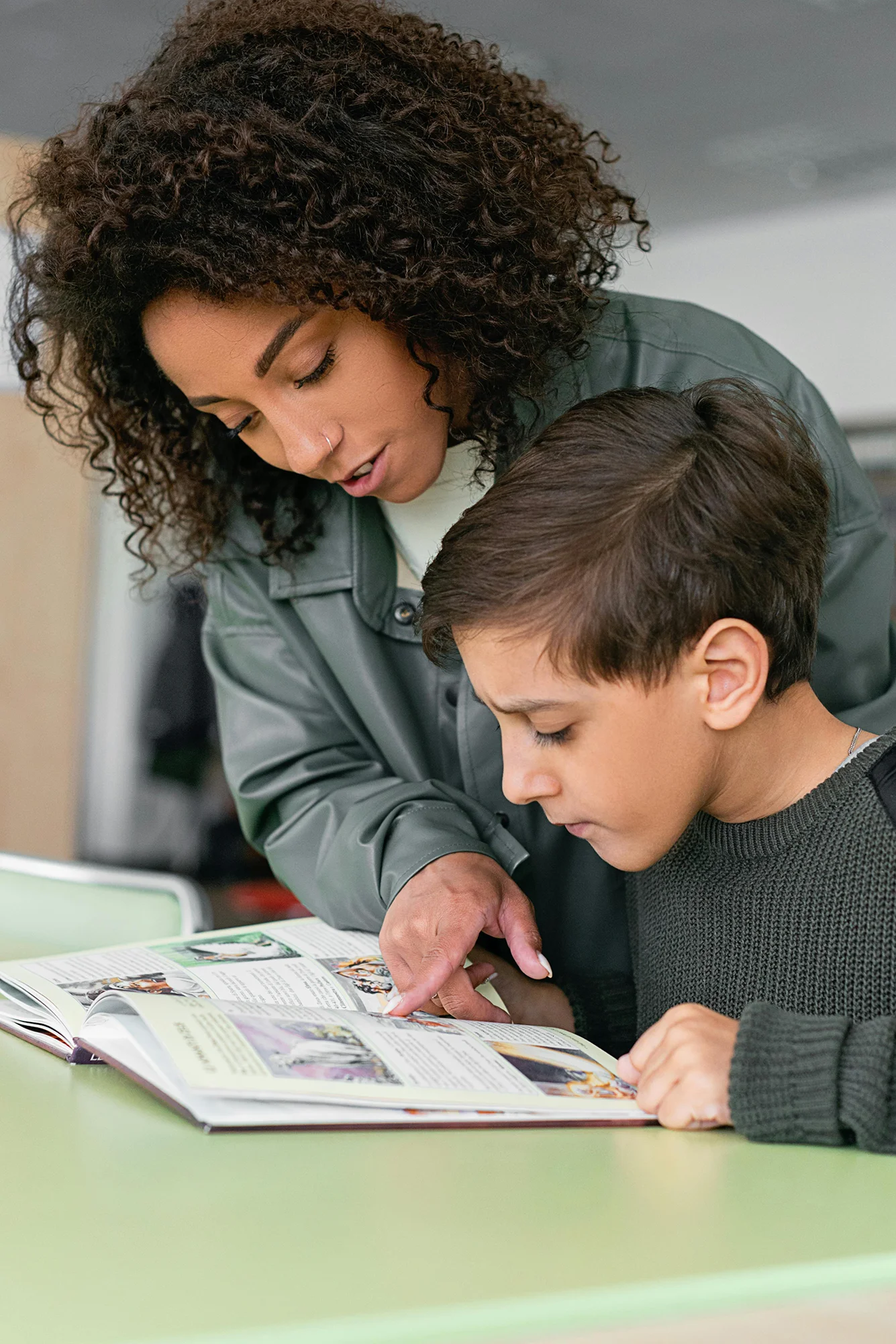A teacher helping a student develop literacy skills
